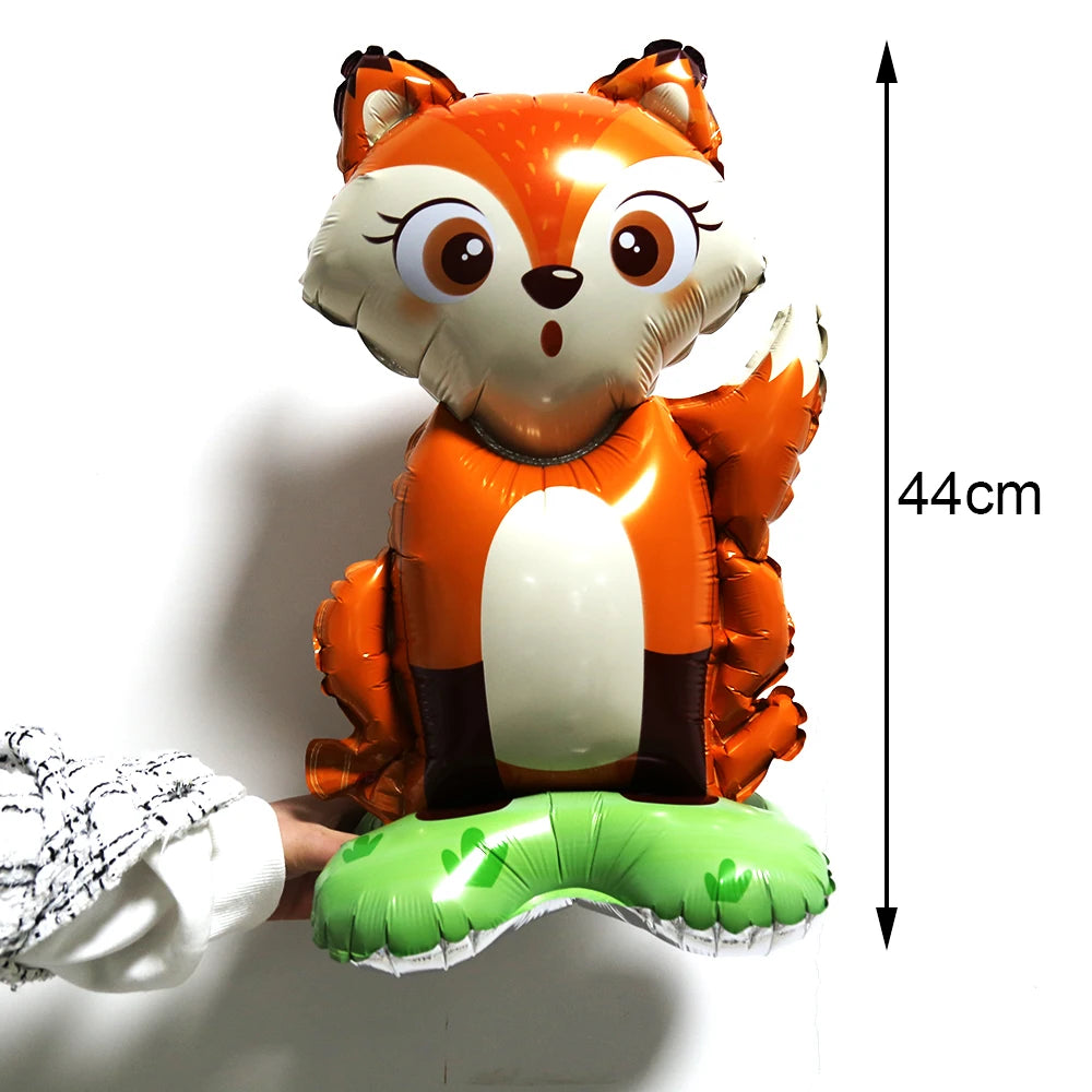 An orange fox-themed balloon decoration with large eyes and ears, shown next to a measuring tape.