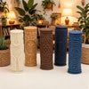 Four cylindrical silicone candle molds in white, tan, brown, and blue sit on a white surface.