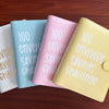 A set of three pastel-colored binders for the 100 Envelope Challenge, showing white, blue, and pink options.