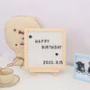 A wooden message board with a white grid displaying Happy Birthday and the date 2023.9.15, next to a light yellow heart-shape