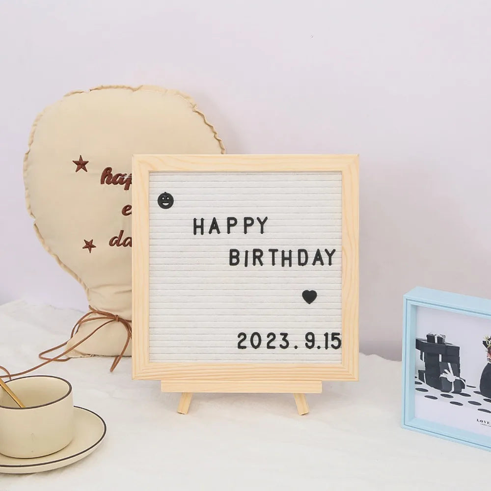 A wooden message board with a white grid displaying Happy Birthday and the date 2023.9.15, next to a light yellow heart-shape
