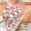 A display of pink and silver balloons arranged in a column stand for an event