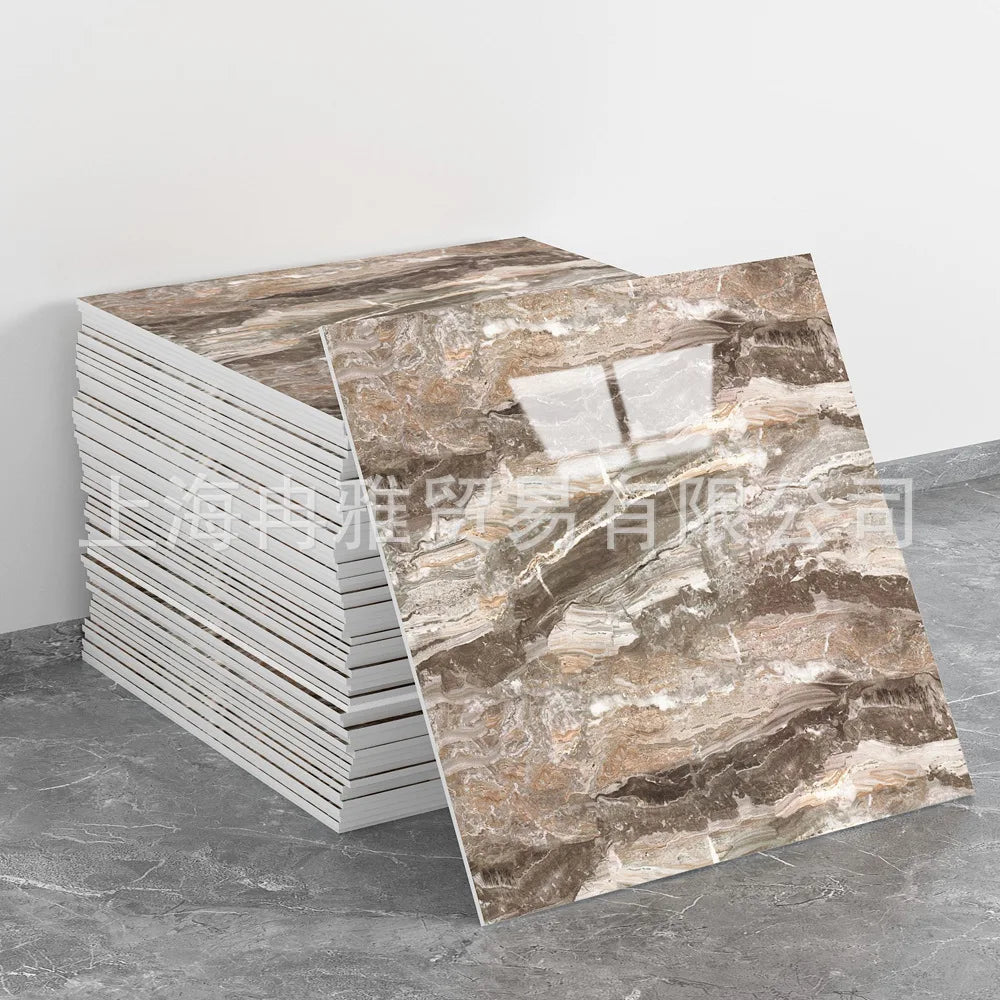 A stack of faux marble 3D self-adhesive wall tiles in brown and beige tones displayed on a gray surface.