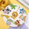 A collection of DIY diamond painting keychains featuring dinosaur, tiger, and animal figures on a white plate.