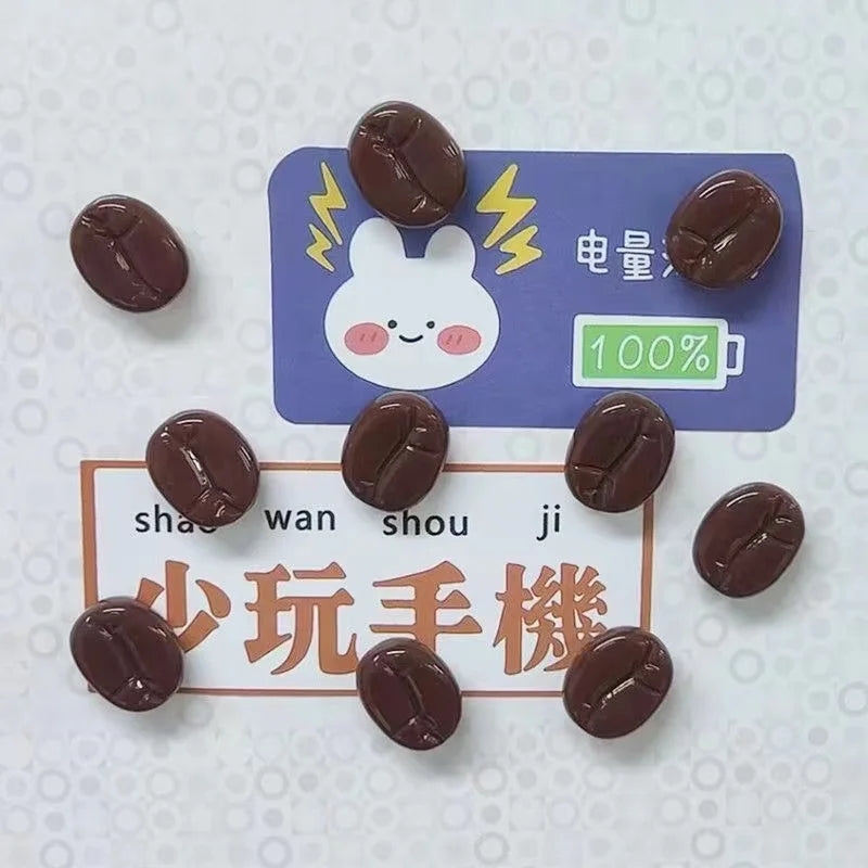 A set of dark brown coffee beans displayed on a purple fridge magnet with a white rabbit design and a 100% symbol.