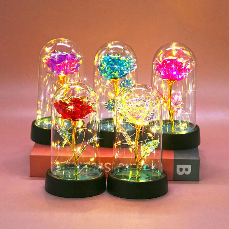 A collection of glass domes featuring vibrant, glowing roses and foliage illuminated by LED lights.