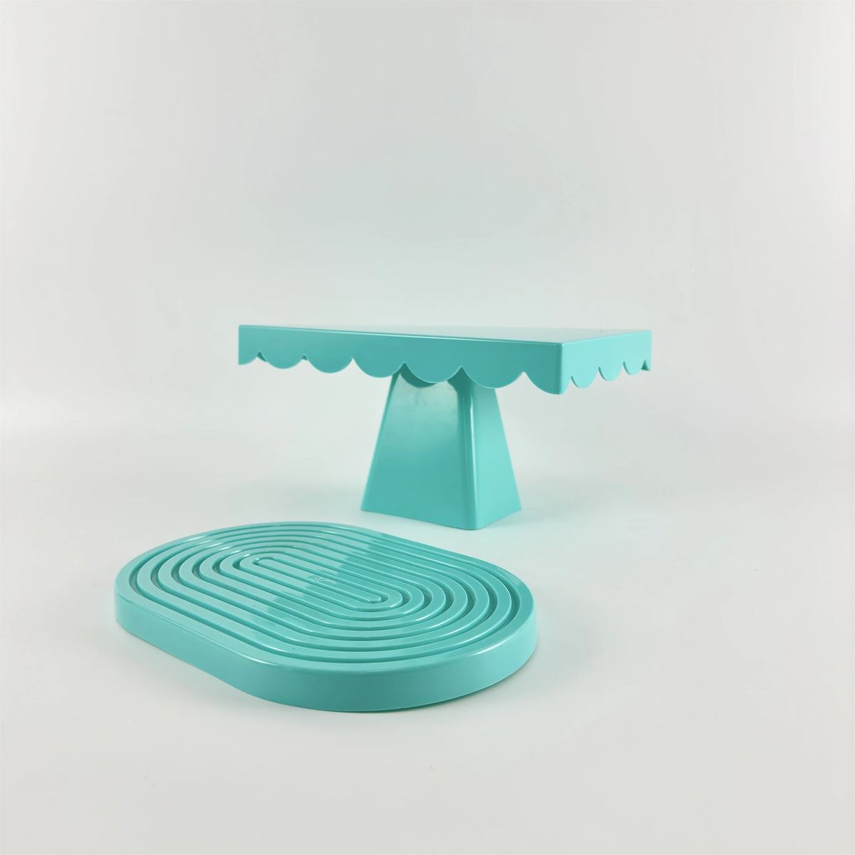 A light blue cupcake stand with a scalloped top and a round, ribbed serving plate.