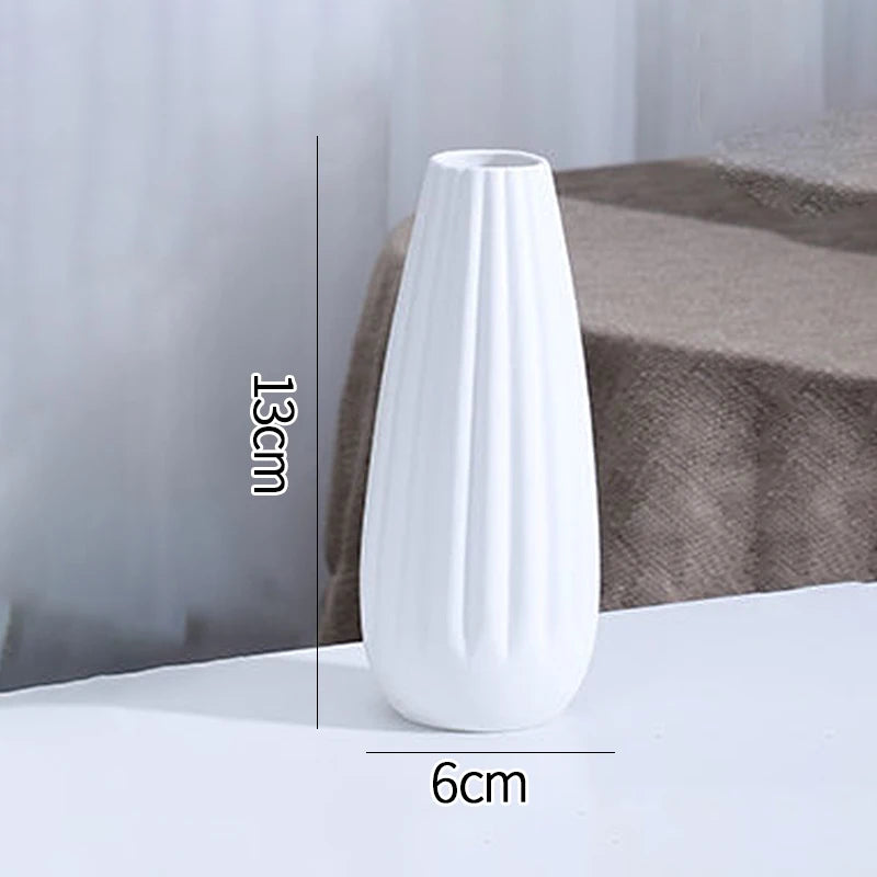 A white ceramic bud vase with vertical ridges is shown on a surface, with dimensions marked.