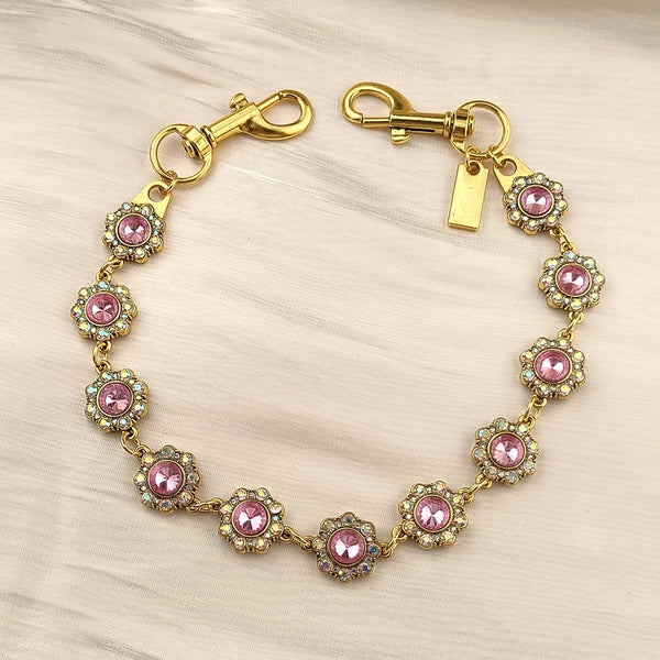 Gold bag chain extender featuring pink and purple rhinestones on a delicate bracelet.