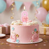 Pink cake decorated with glitter numbers and flowers, featuring a lit candle on top.