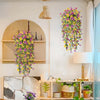 A display of vibrant faux silk flowers in yellow and purple cascading down a white wall.