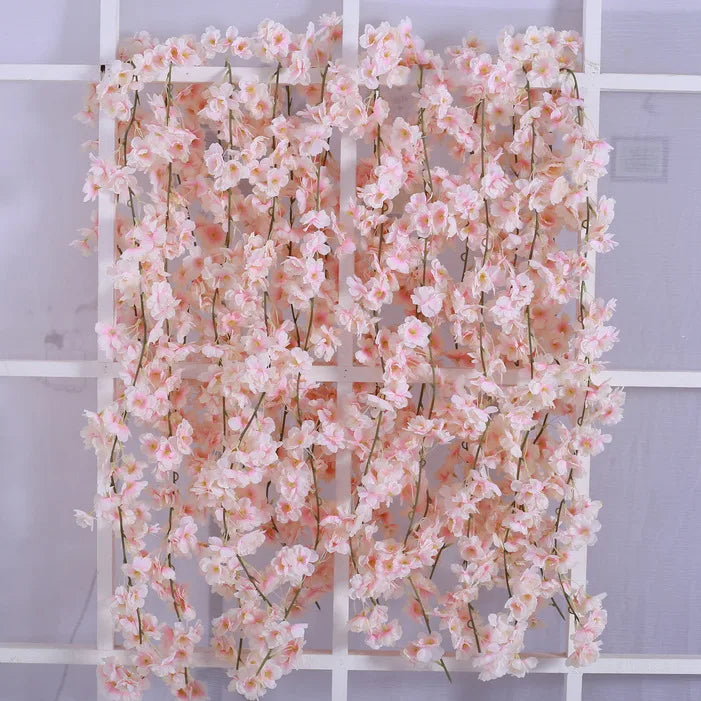Pink sakura flower garland with delicate pink blossoms displayed on a white grid.
