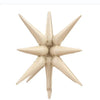 A beige star burst foil balloon with pointed petals for party decor.