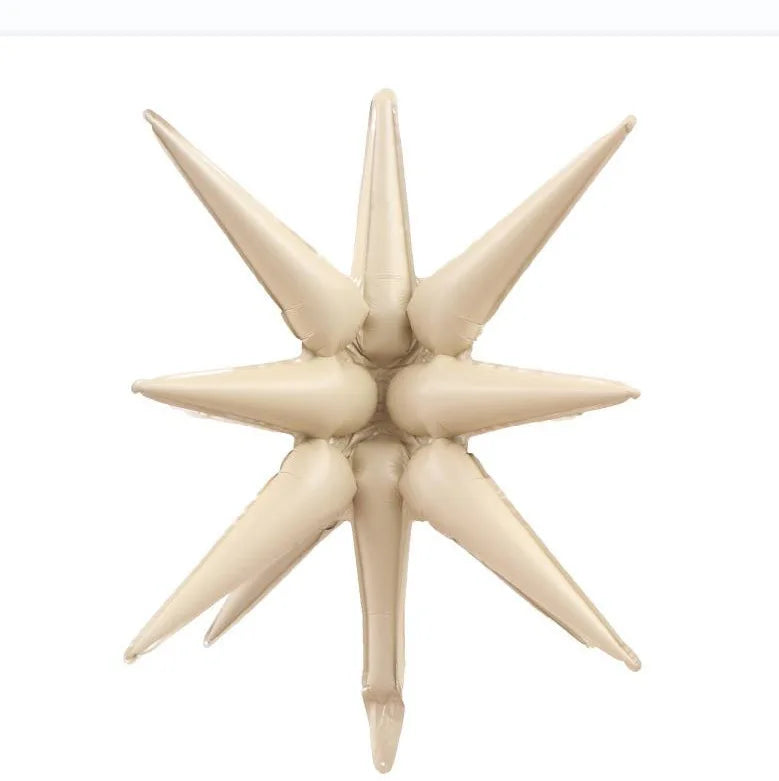 A beige star burst foil balloon with pointed petals for party decor.