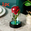 Ein Glasvase mit roter Rose und grünem Stiel wird von einer LED-Lampe beleuchtet, auf einer schwarzen Basis platziert.