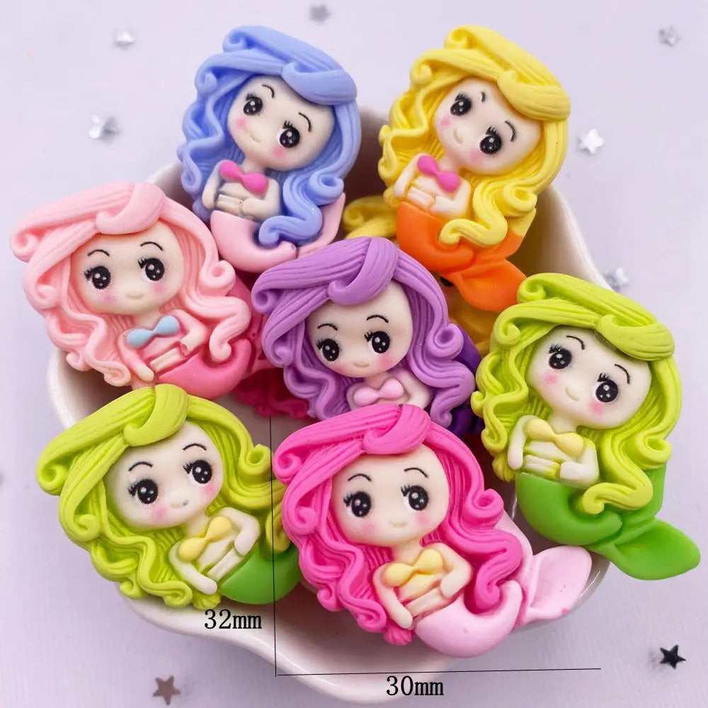 A collection of colorful resin figurines depicting mermaid princesses with curly hair and sweet expressions.