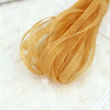 A bundle of golden yellow decorative fishtail yarn ribbon laid on a white surface.
