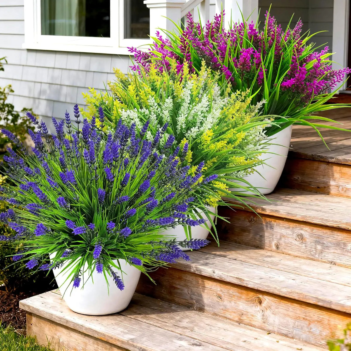 A vibrant display of artificial lavender and yellow flowers in white pots arranged on wooden steps.