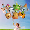 A young girl is holding a bunch of colorful jungle animal foil balloons against a blue sky.