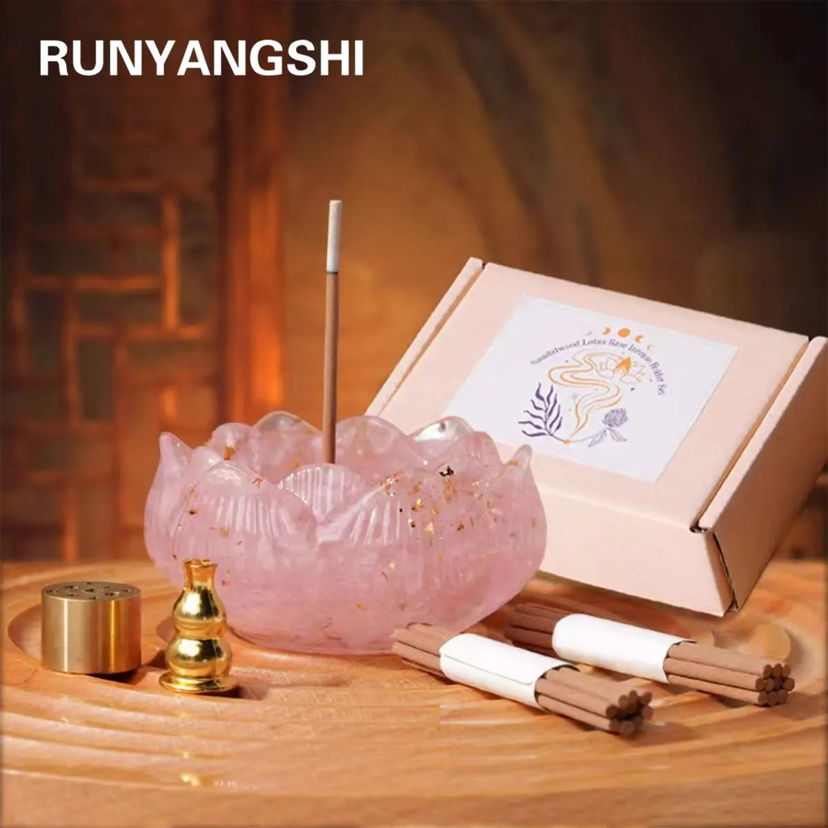 A pink crystal dropper candle set with a wooden stick and incense sticks displayed on a wooden surface.