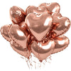 A cluster of rose gold heart-shaped foil balloons tied together for a celebration.