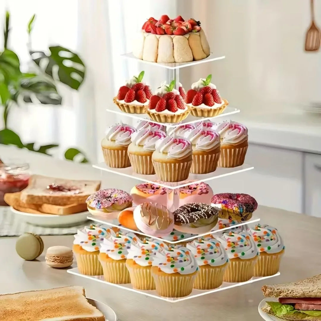 A tiered transparent acrylic cupcake stand filled with various frosted cupcakes and fresh strawberries.