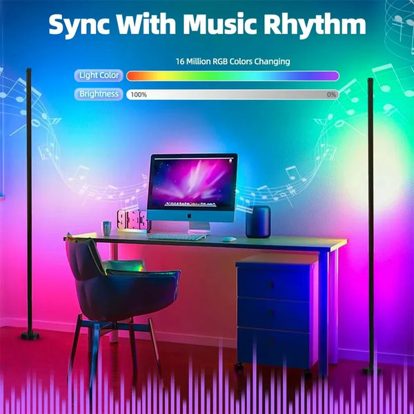 A desk setup featuring a computer monitor, keyboard, and a blue cabinet, illuminated by vibrant RGB light from floor lamps.