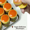 A hand holds a mini burger toy with a magnetic slider mechanism, showing the colorful food item.