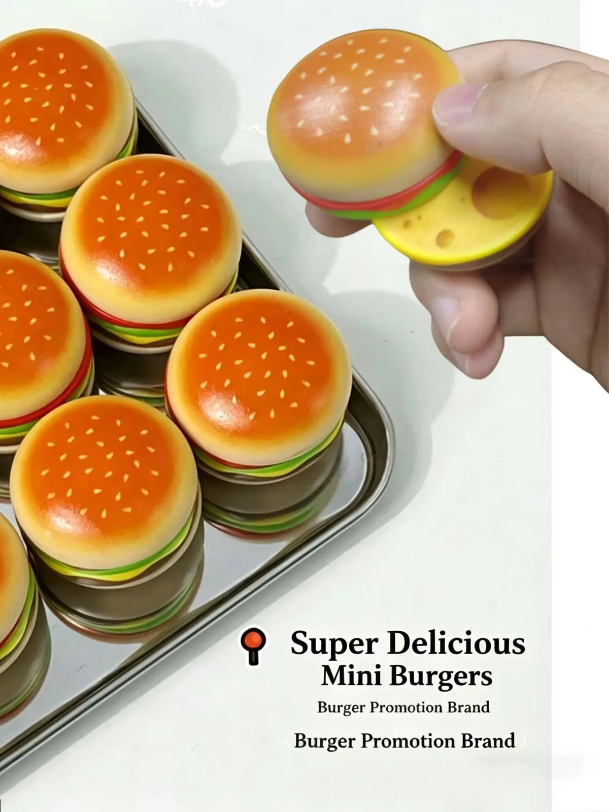 A hand holds a mini burger toy with a magnetic slider mechanism, showing the colorful food item.
