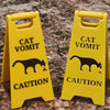 Two yellow plastic yard signs with black silhouettes of cats and dogs and the word CAUTION