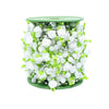A cylindrical arrangement of white roses and green leaves used as a floral garland or ribbon.