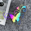 A colorful butterfly vinyl sticker with swirling lines is placed on a gray, textured surface.