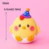 A yellow chick cake topper with a purple and blue hat and pink accents.
