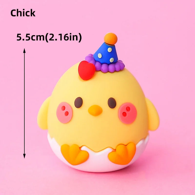 A yellow chick cake topper with a purple and blue hat and pink accents.
