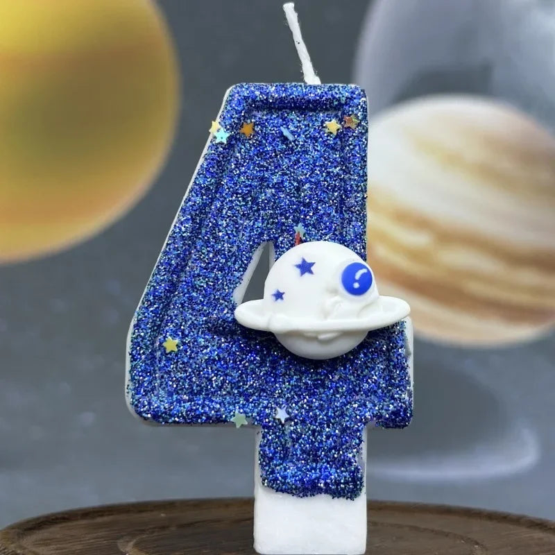 A blue glitter number four candle decorated with stars and a white planet design.