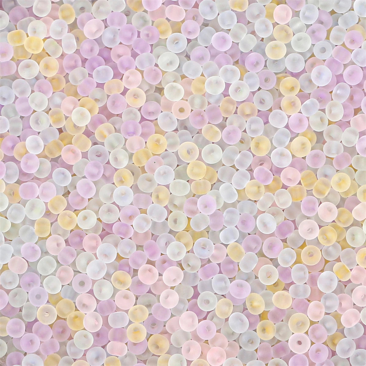 A close-up view of various shades of pink, yellow, and white frosted glass rice beads.