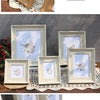A collection of vintage resin photo frames in natural wood tones displayed on a wooden surface.