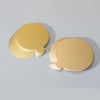 A stack of metallic gold dessert cake boards with silver edges, shown on a light gray surface.