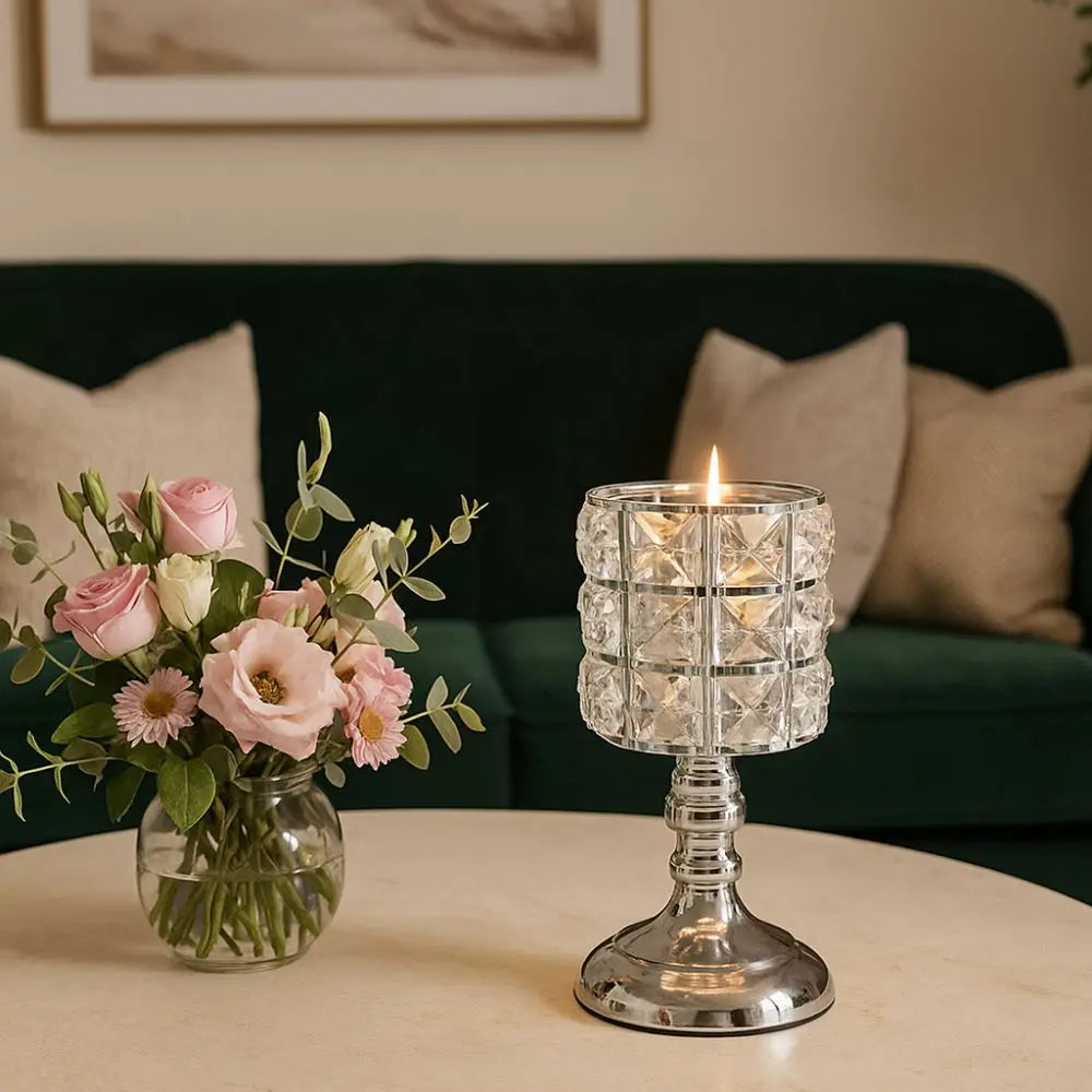 Un candelabro de cristal claro se encuentra en una mesa clara junto a un arreglo floral rosa.