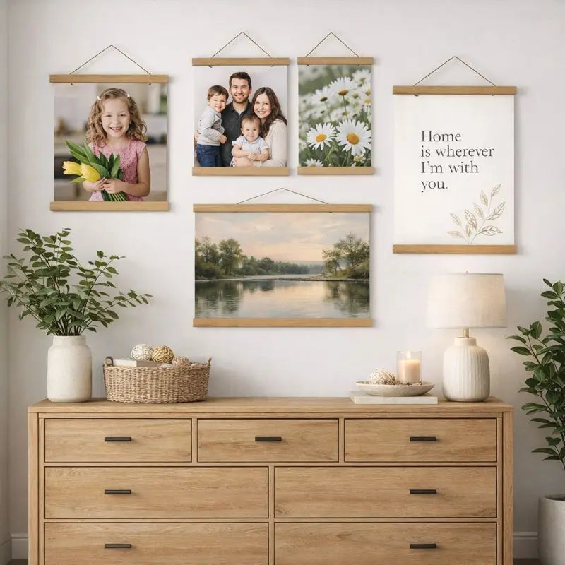 A collection of framed family portraits and nature scenes displayed on a white wall above a light wood cabinet.