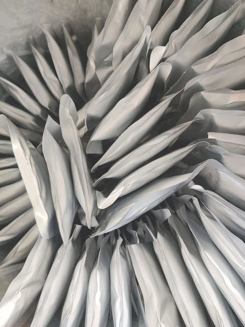A close-up view of a refill of titanium powder for a cold spark machine, showing numerous silver-gray, cone-shaped packets.
