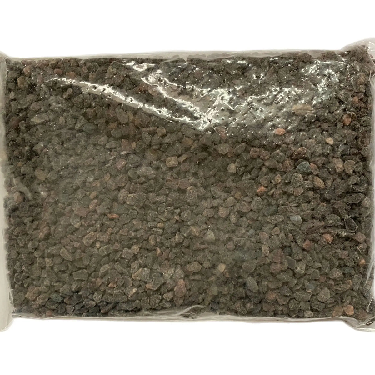 A sealed plastic bag containing dark brown black salt granules.