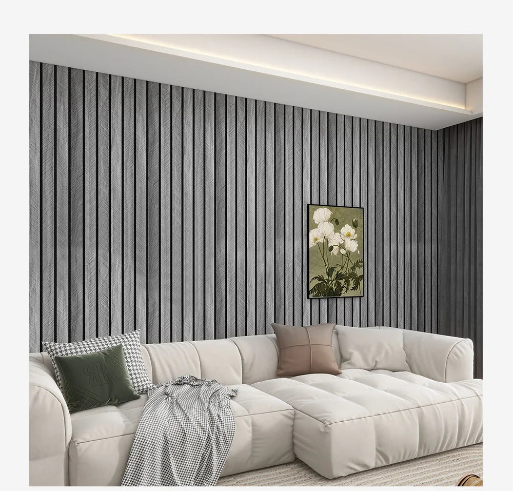 A modern living room featuring a light beige sofa and dark gray vertical wood grain wallpaper.