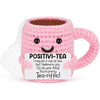 Handmade pink crochet tea cup ornament with a smiling face and motivational text