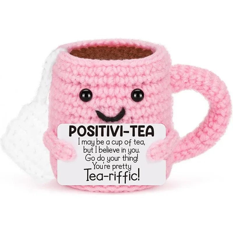 Handmade pink crochet tea cup ornament with a smiling face and motivational text