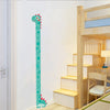 A wooden height chart with dinosaur and giraffe stickers mounted on a white wall in a child's room.