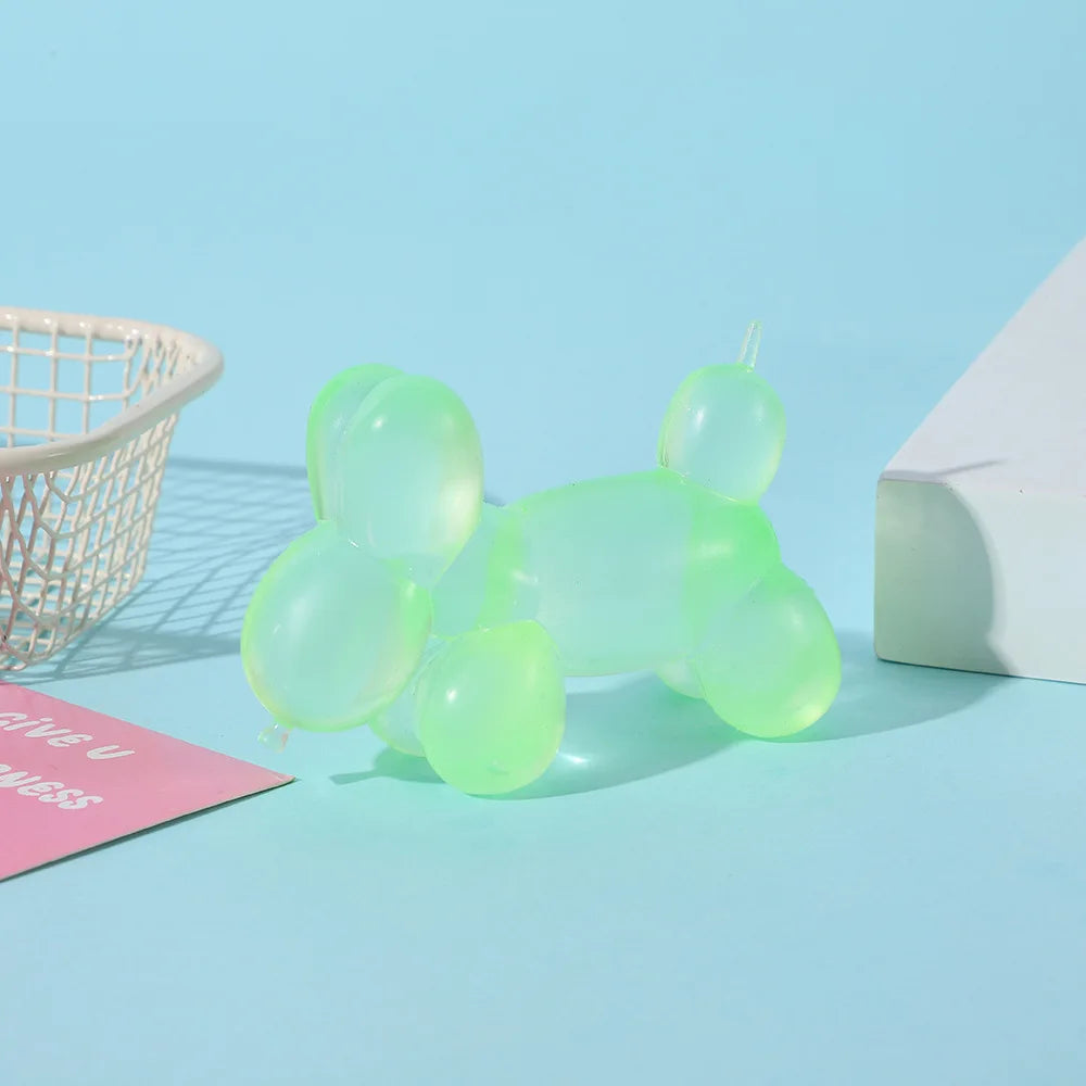 A collection of translucent light green squishy toys arranged on a blue surface next to a white basket and a white box.