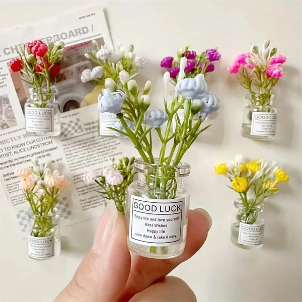 Une main tient un bocal rempli de fleurs et de feuilles séchées colorées pour la décoration.