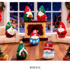 A festive resin Christmas dwarf figurine set featuring Santa and snowmen figures displayed in a living room setting.