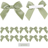 A set of green satin ribbon bows with self-adhesive backing for crafting and gift wrapping.
